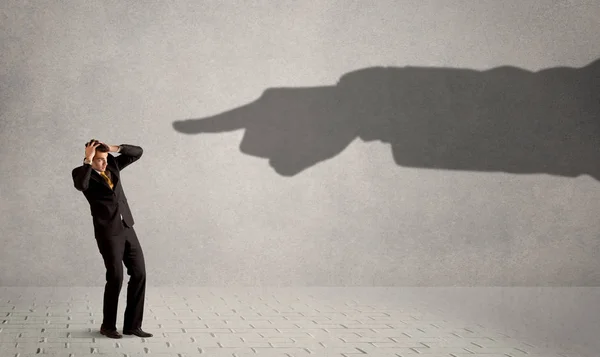 Persona de negocios mirando enorme sombra mano apuntando a él conc — Foto de Stock