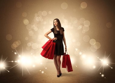 Parlak ışıklarda çantalı alışveriş yapan kadın.