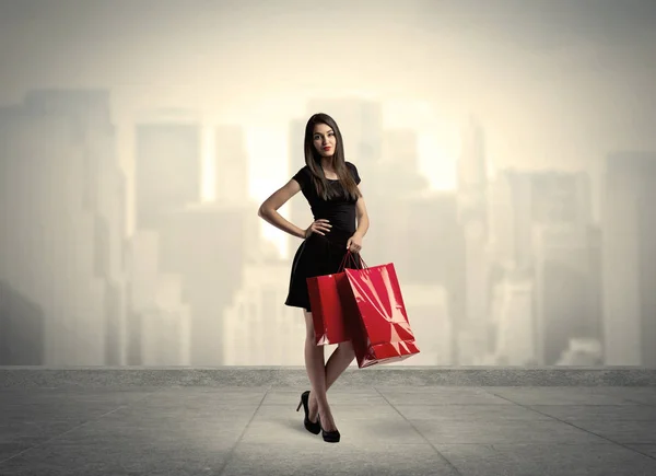 Elegantní město dívka s červenými nákupními taškami — Stock fotografie