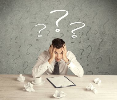 İş adamı soru işaretiyle masada.