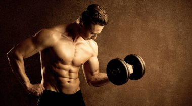 Kas formundaki vücut geliştirici sporcu ağırlık kaldırıyor 