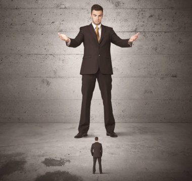 Büyük bir iş adamı küçük bir iş arkadaşına bakıyor.