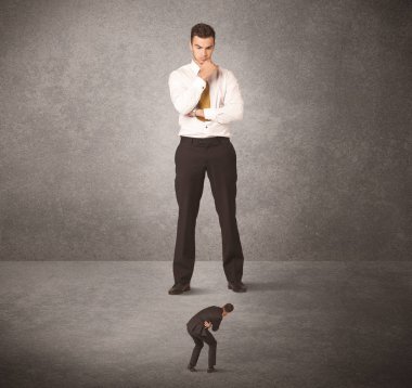 Büyük iş adamı küçük işçilere bakıyor.