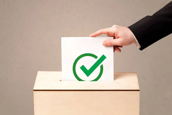 Nahaufnahme einer männlichen Hand, die ihre Stimme in eine Wahlurne wirft — Stockfoto