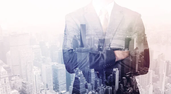 Business man standing on roof with city in the background — Stock Photo, Image