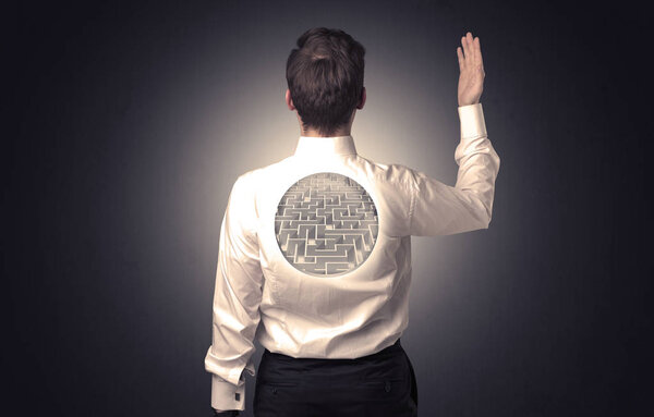 Businessman standing with maze on his back