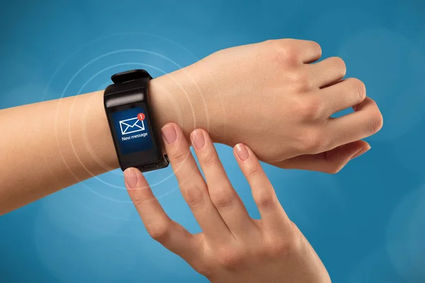 Mano con smartwatch e sfondo blu — Foto Stock