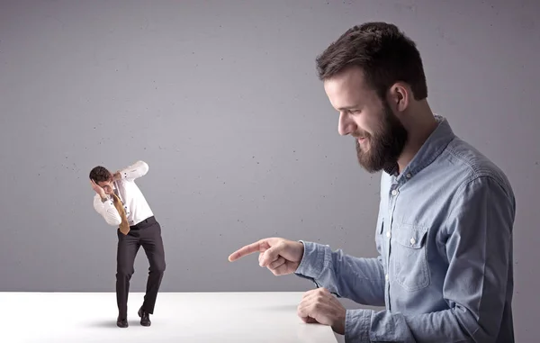 Giovane uomo d'affari che lotta con uomo d'affari in miniatura — Foto Stock