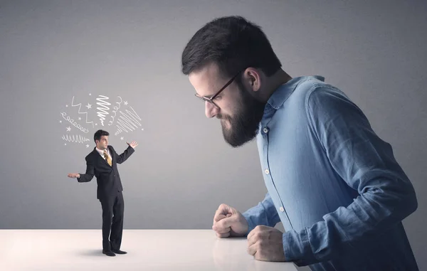 Young businessman fighting with miniature businessman — Stock Photo, Image