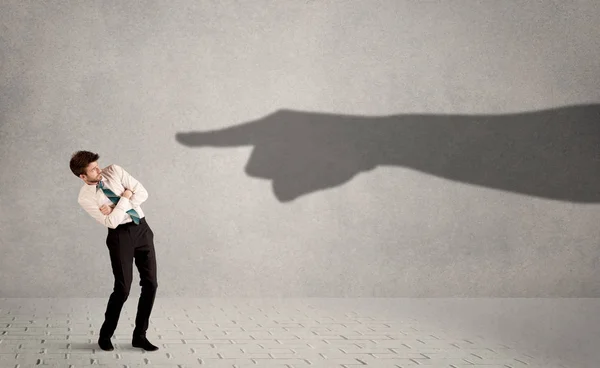 Persona de negocios mirando enorme sombra mano apuntando a él conc — Foto de Stock