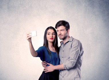 Mutlu çift temiz duvarlı selfie çekiyor.