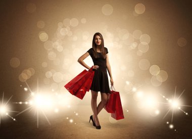 Parlak ışıklarda çantalı alışveriş yapan kadın.