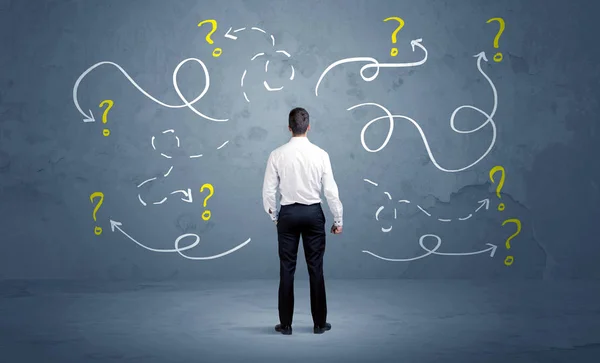 Unsure businessman with question marks — Stock Photo, Image