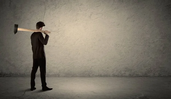 Επιχειρηματίας στέκεται μπροστά από ένα grungy τοίχο με ένα σφυρί — Φωτογραφία Αρχείου