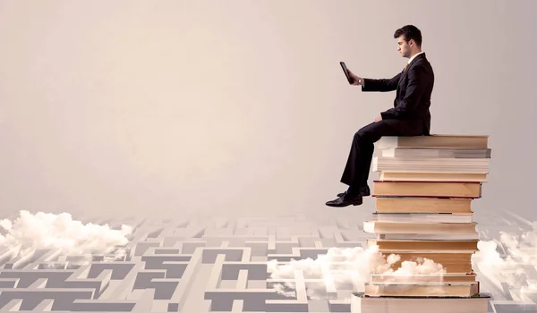 Hombre con tableta sentado en los libros — Foto de Stock