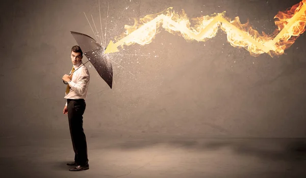 Business man defending himself from a fire arrow with an umbrell — Stock Photo, Image