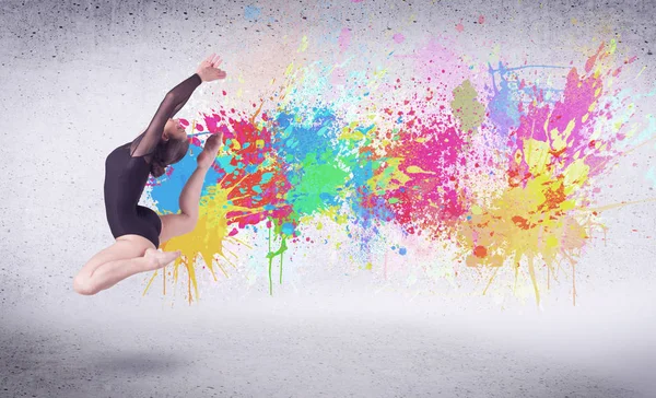 Modern street dancer jumping with colorful paint splashes — Stock Photo, Image