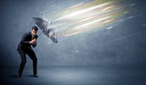 Homme d'affaires défendant les faisceaux lumineux avec concept de parapluie — Photo