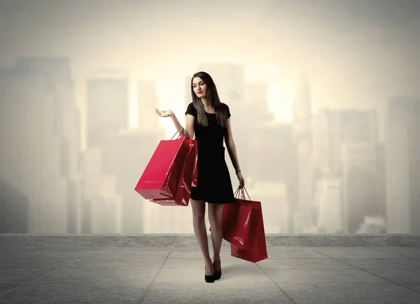 Kırmızı alışveriş çantalı zarif şehir kızı. — Stok fotoğraf