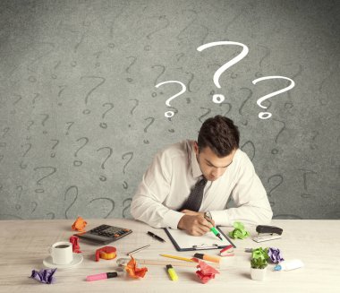 İş adamı soru işaretiyle masada.