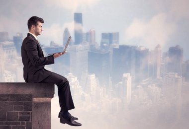 Yüksek bir binanın tepesinde oturan satıcı.