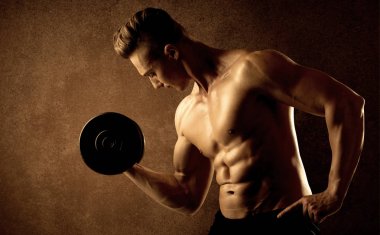 Kas formundaki vücut geliştirici sporcu ağırlık kaldırıyor 