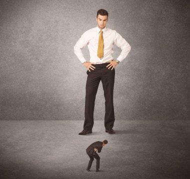 Büyük iş adamı küçük işçilere bakıyor.