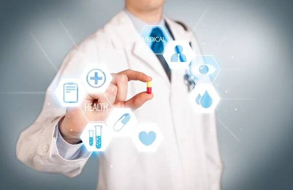 A doctor in white holding a pill — Stock Photo, Image