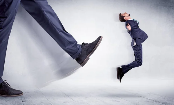 Grande perna chutando pequeno homem — Fotografia de Stock