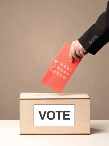 Fechar a mão masculina colocando voto em uma urna — Fotografia de Stock