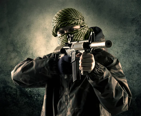Porträt eines schwer bewaffneten, maskierten Soldaten mit grundiertem Hintergrund — Stockfoto