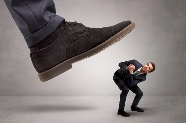 Klein mannetje met voeten getreden door de grote kracht — Stockfoto