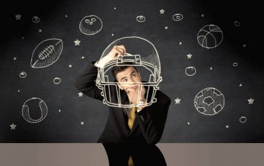 İş adamı miğfer ve spor topu çiziyor.