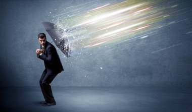 Şemsiye konseptiyle ışık demetlerini savunan iş adamı