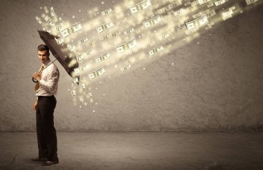 İş adamı dolar yağmuruna karşı şemsiye tutuyor