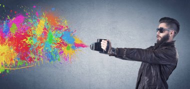 Kamera ve boya sıçratan hippi adam.