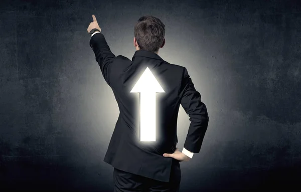 Young businessman standing with arrow on his back — Stock Photo, Image