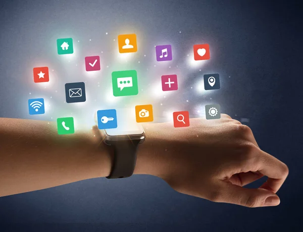 Vrouwelijke hand dragen smartwatch met app pictogrammen — Stockfoto
