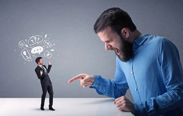 Young businessman fighting with miniature businessman — Stock Photo, Image