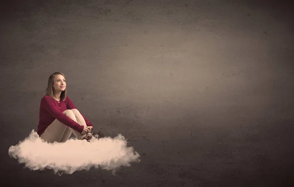 Woman sitting on a cloud with plain bakcground — Stock Photo, Image