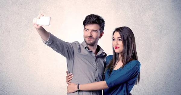 Mutlu çift temiz duvarlı selfie çekiyor.