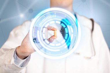 Erkek doktor elinde parlak halkaları olan bir hap tutuyor.