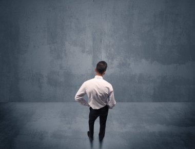 Şehir duvarının önünde duran iş adamı