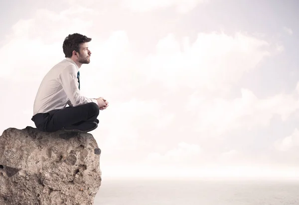 Business man sitting on stone edge — Stock Photo, Image