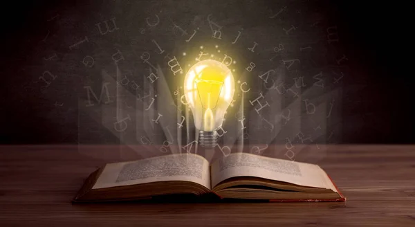 Bokstäver och glödlampa över bok — Stockfoto