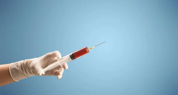 Médico femenino sosteniendo jeringa — Foto de Stock