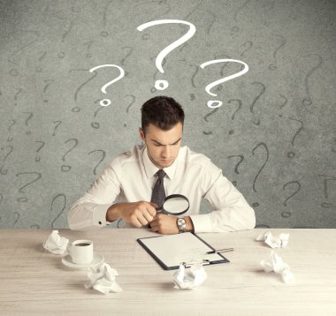 İş adamı soru işaretiyle masada.