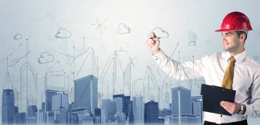 Genç işçi şehir manzarası çiziyor.