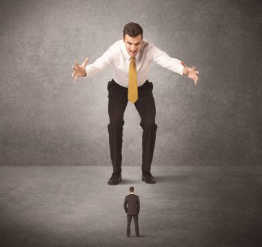 Büyük iş adamı küçük işçilere bakıyor.