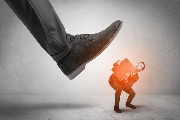 Large foot stepping down small man — Stock Photo, Image